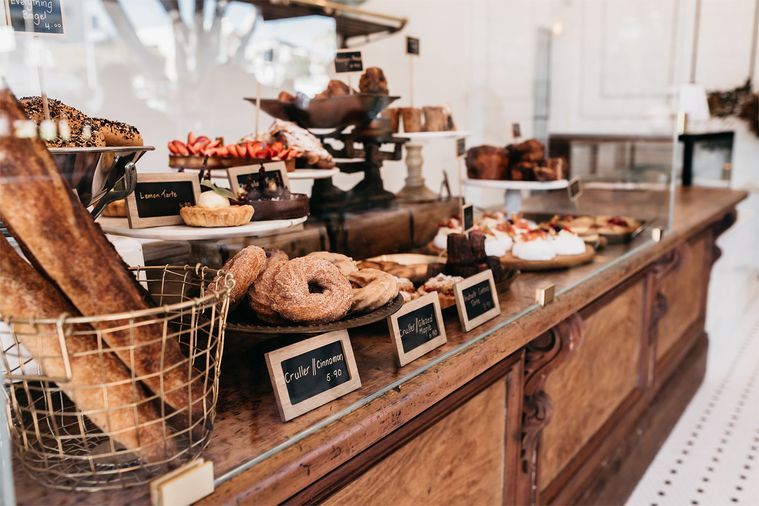A bakery counter filled with artisan pastries, sourdough, and desserts at a charming café—one of the must-visit places to eat in Burleigh Heads.